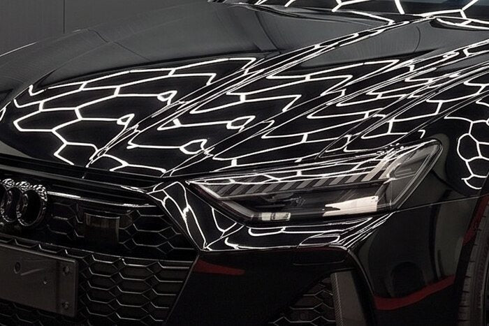 Zwarte lak van dichtbij, met de hexagonale verlichting erin weerspiegeld