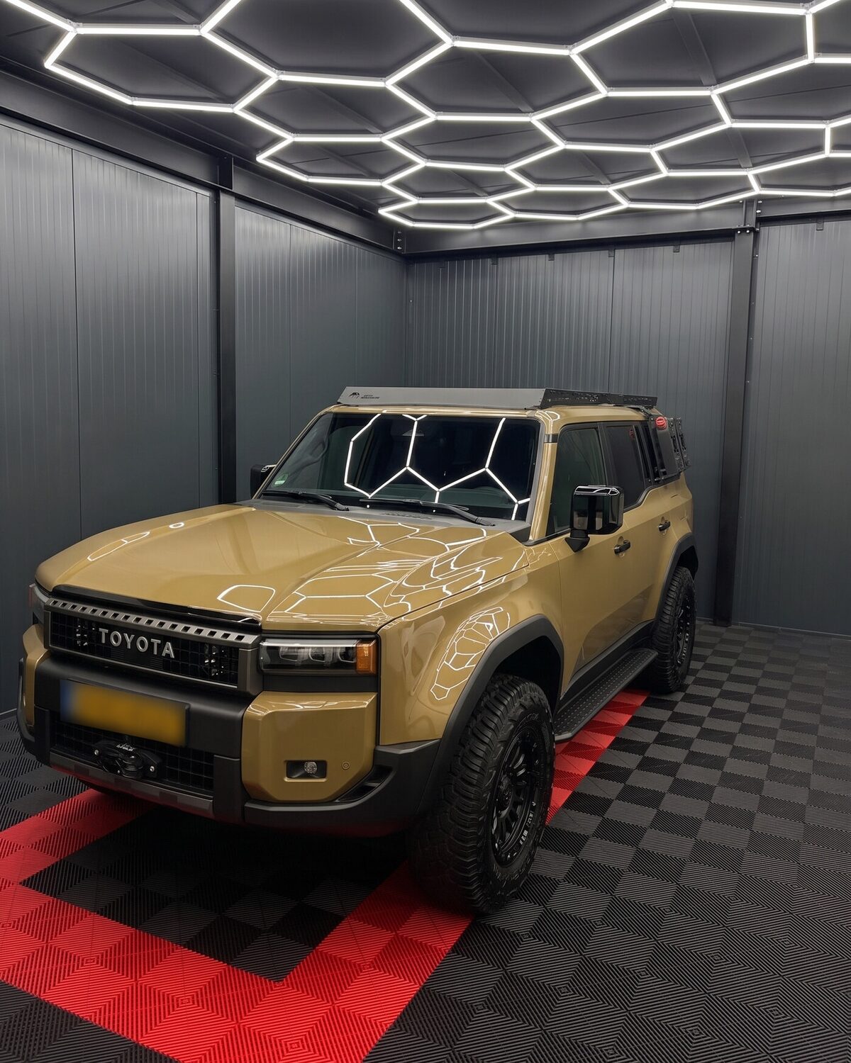 Zandkleurige Toyota Land Cruiser op de rode opstelplaats