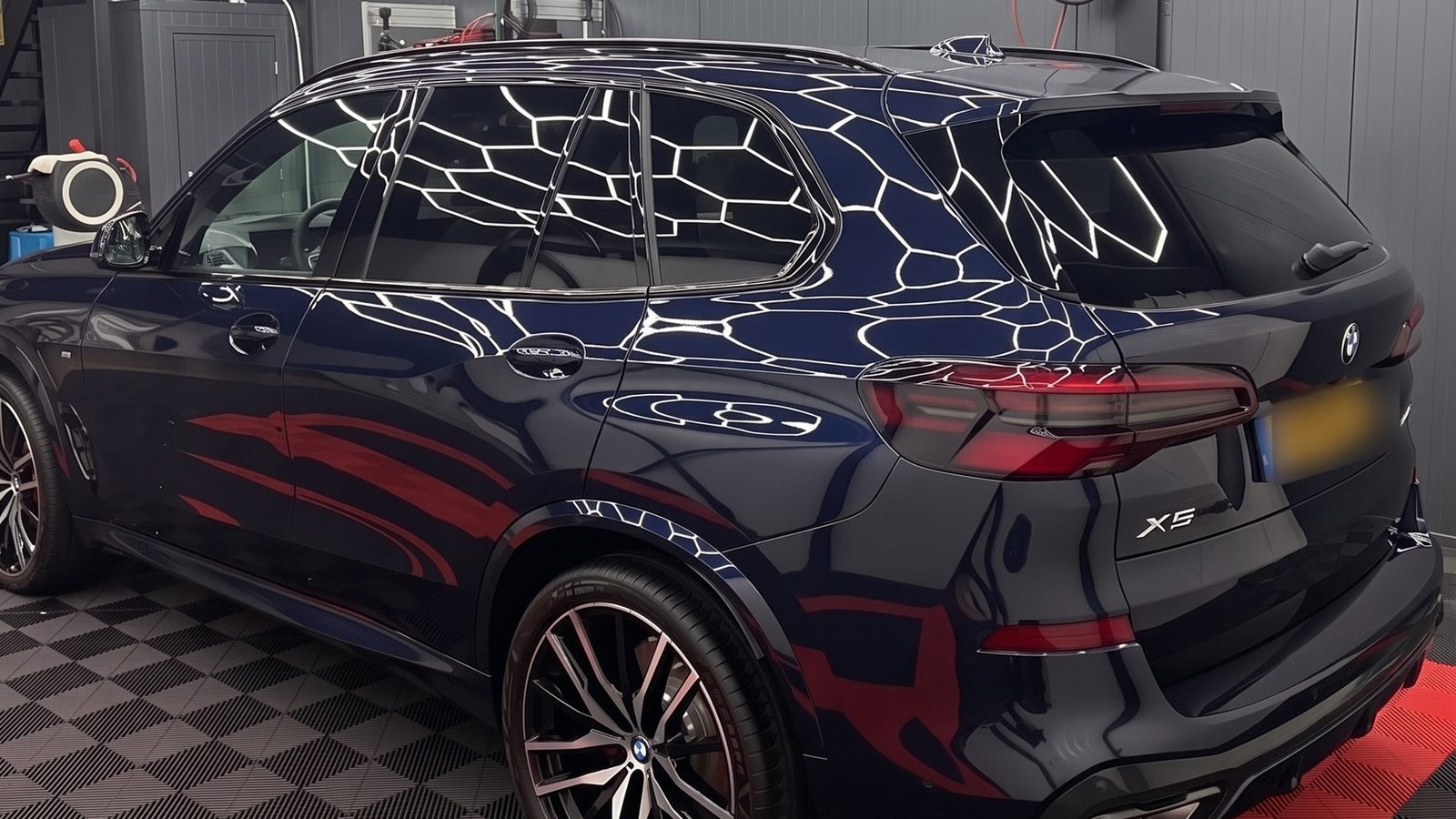 Donkerblauwe BMW X5 van achteren in de werkplaats