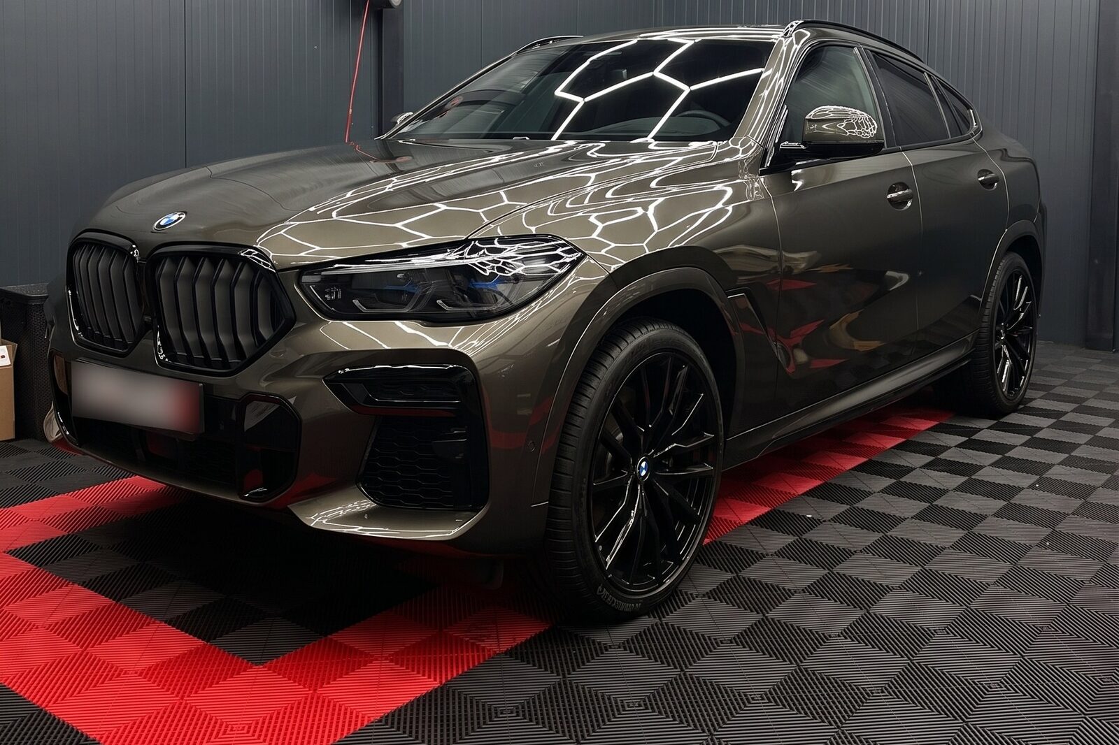Bronskleurige BMW X6 van voren in de werkplaats